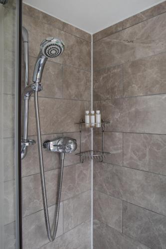 a shower with a shower head in a bathroom at Ocean House in St Ives