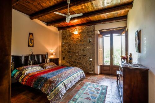a bedroom with a bed and a stone wall at Lolivia Masseria & Ristoro in Senise