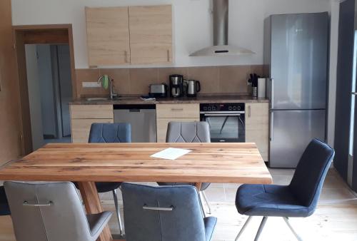 a kitchen with a wooden table and blue chairs at Wohnung in Datteln in Datteln