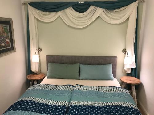a bedroom with a bed with a canopy and two tables at Ferienwohnung am Hörnle in Bad Kohlgrub