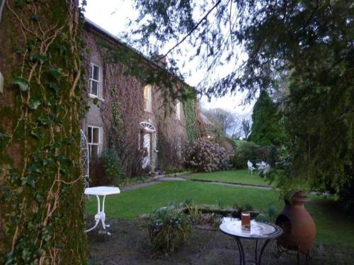 a house with a table and a chair in the yard at Cullintra House in New Ross