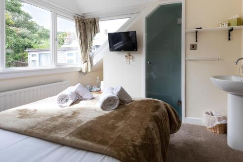 a bedroom with a bed and a sink and a window at Ocean House in St Ives