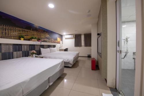 um quarto de hotel com duas camas e um chuveiro em England Vacation Hotel em Zhongli