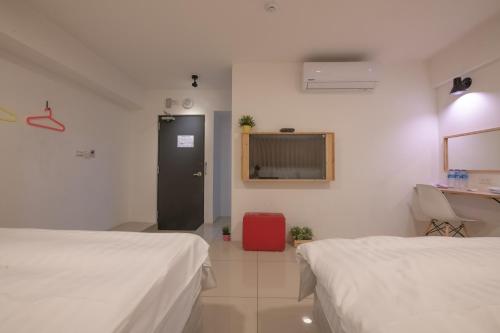 a hospital room with two beds and a red suitcase at England Vacation Hotel in Zhongli
