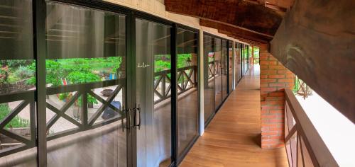 a hallway with glass windows and a brick wall at Latica Lodge in Playa Negra