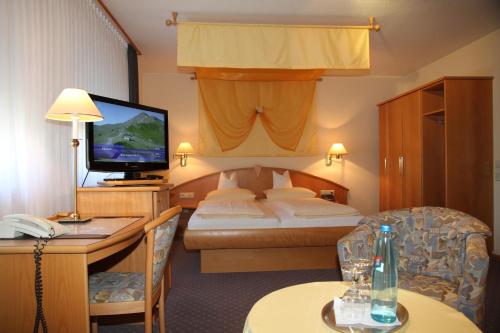 a hotel room with a bed and a television at Hotel Anika in Neuenburg am Rhein