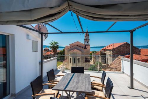 d'une terrasse avec une table et des chaises en bois sur un balcon. dans l'établissement Apartments Villa Castello, à Kaštela