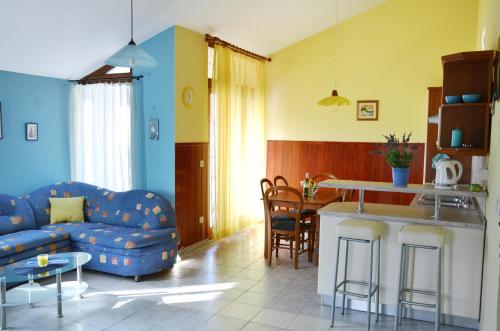 a living room with a blue couch and a kitchen at Apartman I&A in Porat