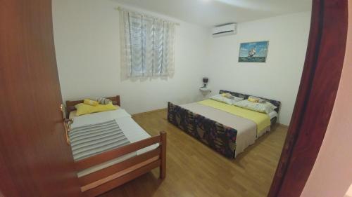 a bedroom with two beds and a window at Villa Franko in Prizna