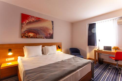 a hotel room with a bed and a desk at Best Western Terminus Hotel in Sofia