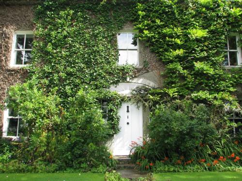 an ivy covered building with a white door at Cullintra House in New Ross