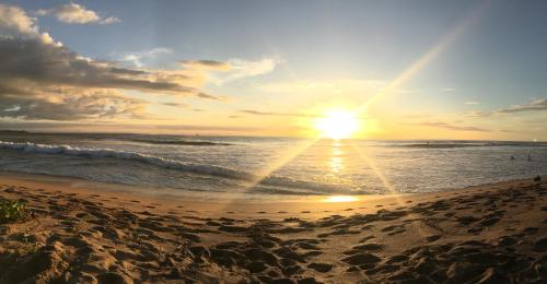 a sunset on a beach with the ocean at Villas Kalei in Playa Grande