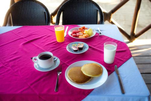 a table with a plate of food and a cup of coffee and pancakes at Casablanca Resort  in Rincon de Guayabitos