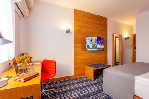 a hotel room with a desk and a bed and aaptop at Best Western Terminus Hotel in Sofia