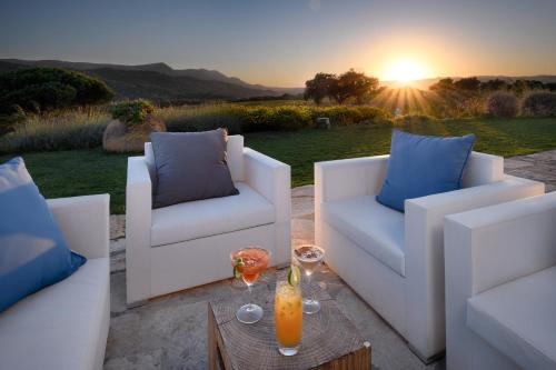 a patio with two couches and a table with drinks at Hotel Casa Palmela - Small Luxury Hotels of The World, Hotel & Villas in Setúbal