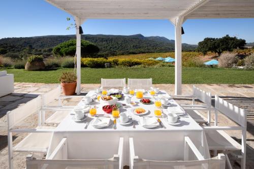 a white table with food and orange juice on it at Hotel Casa Palmela - Small Luxury Hotels of The World, Hotel & Villas in Setúbal