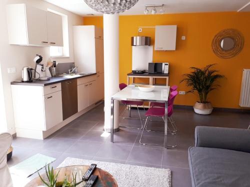 uma cozinha e sala de estar com mesa e cadeiras em Appartement rez Terrasse et Jardin em Huy