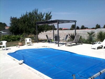 une piscine avec des chaises et un gazebo dans l'établissement Les lauriers, à Arvert