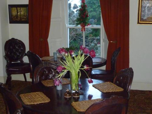 a dining room table with a vase of flowers on it at Cullintra House in New Ross