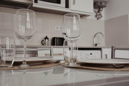 three wine glasses sitting on a counter in a kitchen at Apartamento central, moderno e luminoso - Self check in in Coimbra
