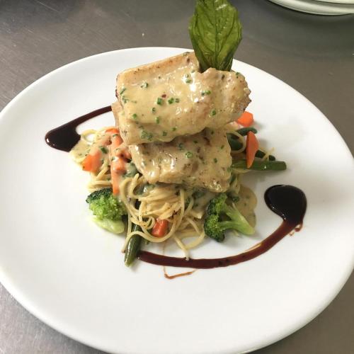 a plate of food with pasta and vegetables on a table at La Masia Hotel Boutique in Anapoima