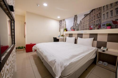 a bedroom with a large white bed in a room at England Vacation Hotel in Zhongli