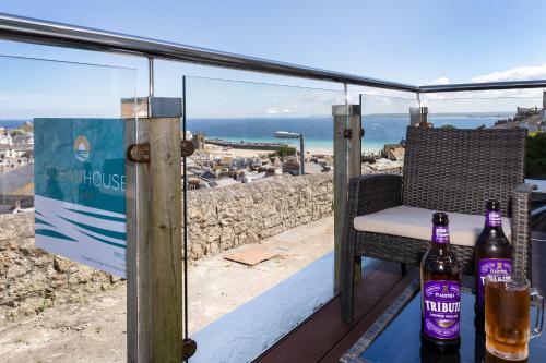 two bottles of beer sitting on a table on a balcony at Ocean House in St Ives