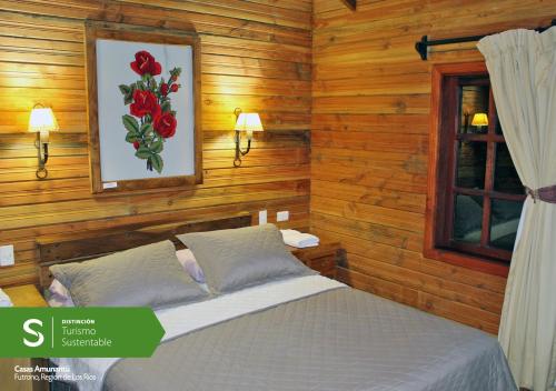 1 dormitorio con 1 cama y una foto de rosas en Cabañas Amunantu, en Futrono