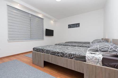Schlafzimmer mit einem Bett und einem Fenster mit Jalousien in der Unterkunft Apartman Emir 1 in Sarajevo