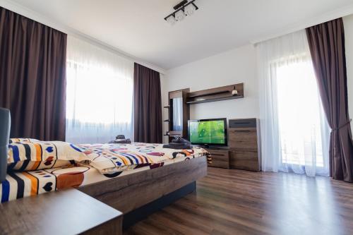 a hotel room with a bed and a television at Aparthotel Laura in Cluj-Napoca