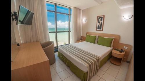 a hotel room with a bed and a window at Golden Park Recife Boa Viagem in Recife