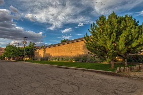 an empty street with a tree next to a building at Rustic Inn in Moab