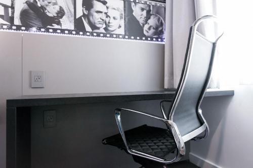 a chair sitting under a window in a room at Glen Capri Inn and Suites - Burbank Universal in Glendale