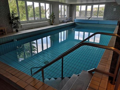 an indoor swimming pool with blue tiles in a building at Ferienwohnung Lydia in Schönwald