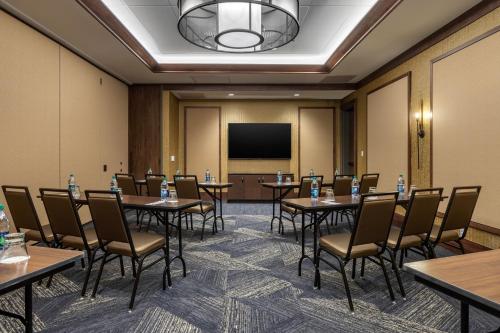 a conference room with tables and chairs and a screen at Cambria Hotel - Arundel Mills BWI Airport in Hanover