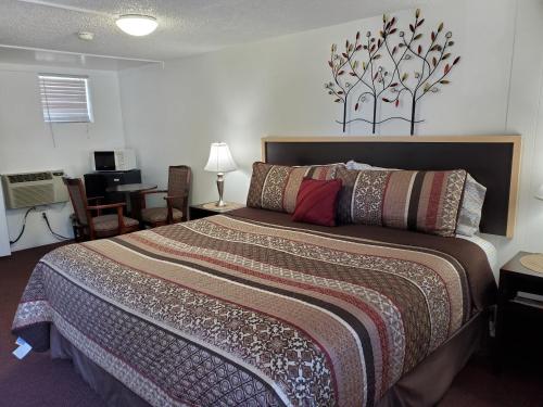 1 dormitorio con 1 cama grande y escritorio en Sonoma Lodge, en Bend