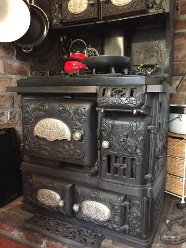 an old black stove with a tea kettle on top at Katys Inn in La Conner
