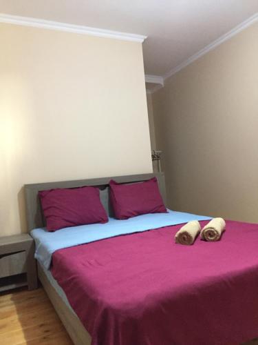 a bedroom with a large bed with purple sheets and pillows at Guest House Marani in Sighnaghi