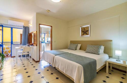 um quarto de hotel com uma cama, uma mesa e uma secretária em Rio by Garvetur em Vilamoura