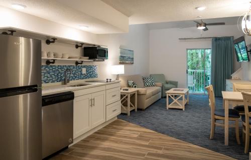 a kitchen and living room with a couch and a table at Palmera Inn and Suites in Hilton Head Island