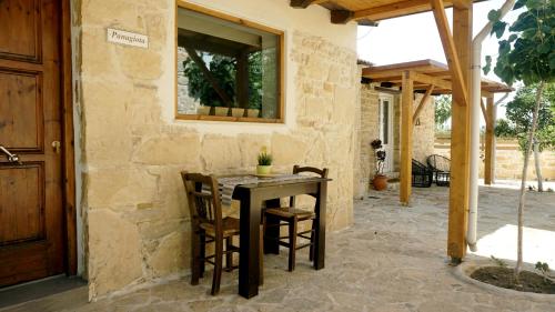 a patio with a table and chairs in front of a building at Studio Panagiota - Oasis holiday houses in Kókkinos Pírgos