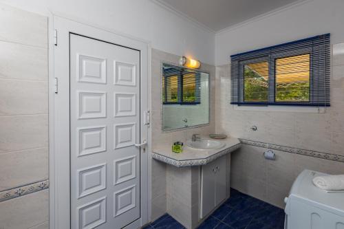 a white bathroom with a sink and a mirror at Villa Pelagia in Svoronata