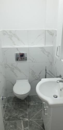 a white bathroom with a toilet and a sink at Tondo in Tivat