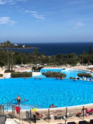 une grande piscine bleue avec des gens dedans dans l'établissement Cap Esterel Appartement haut de gamme, à Saint-Raphaël