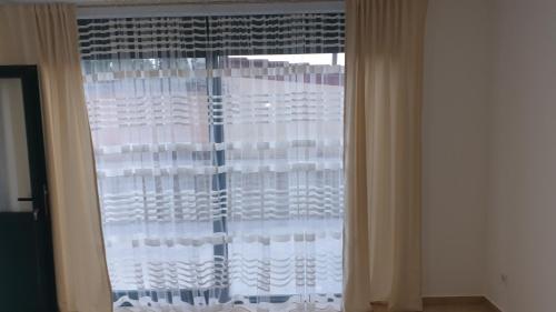 a window with white curtains in a room at Tondo in Tivat