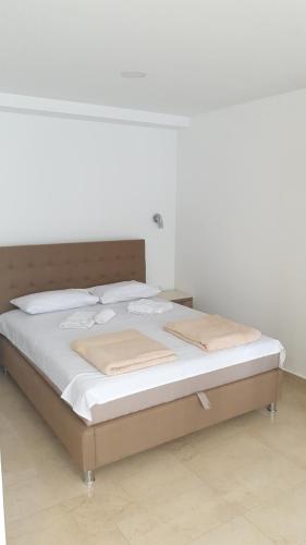 a bed with white sheets and pillows in a room at Tondo in Tivat