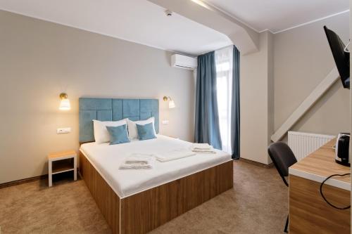 a hotel room with a bed and a desk at Hotel Bordeaux in Galaţi