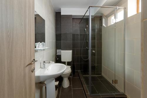 e bagno con servizi igienici, lavandino e doccia. di Hotel Bordeaux a Galaţi