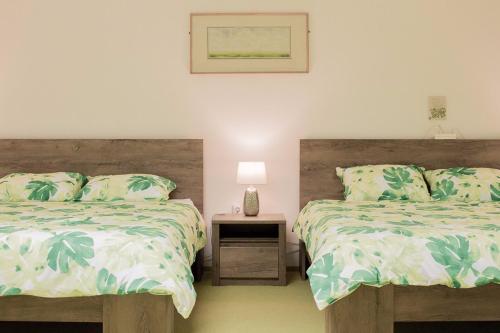 a bedroom with two beds and a table with a lamp at Ioan Budai-Deleanu Apartment in Cluj-Napoca
