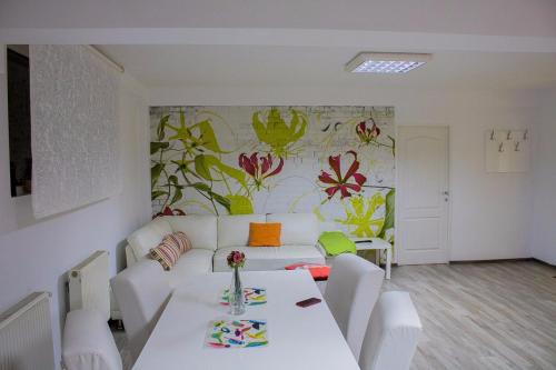 a living room with a white couch and a table at Ioan Budai-Deleanu Apartment in Cluj-Napoca